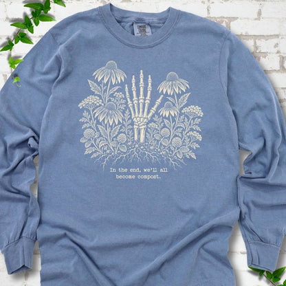 Blue Jean Comfort Colors® long sleeve T-shirt featuring a cream botanical skeleton-hand graphic reading In the end, we'll all become compost
