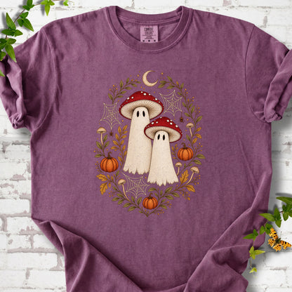 Berry Comfort Colors® T-shirt laid flat, showing two cream ghosts wearing red mushroom caps, surrounded by small pumpkins, autumn leaves and a crescent moon.