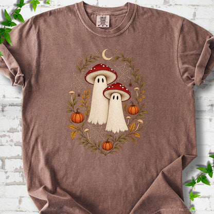 Espresso Comfort Colors® T-shirt laid flat, showing two cream ghosts wearing red mushroom caps, surrounded by small pumpkins, autumn leaves and a crescent moon.
