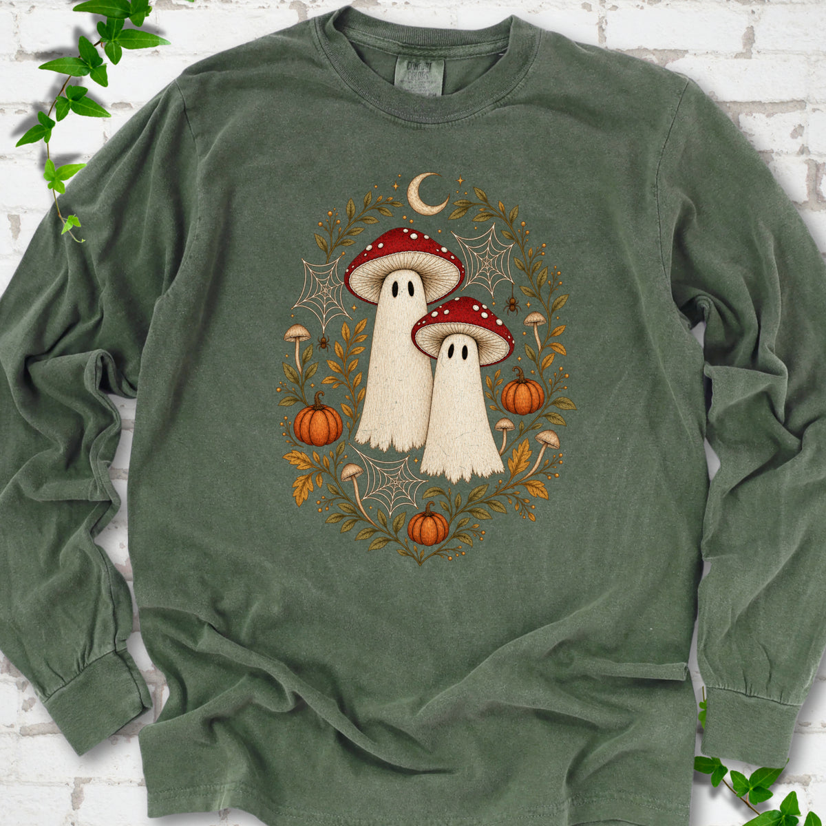 Hemp Comfort Colors® long sleeve T-shirt laid flat, showing two cream ghosts wearing red mushroom caps, surrounded by small pumpkins, autumn leaves and a crescent moon.