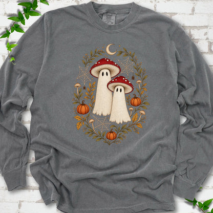 Pepper Comfort Colors® long sleeve T-shirt laid flat, showing two cream ghosts wearing red mushroom caps, surrounded by small pumpkins, autumn leaves and a crescent moon.