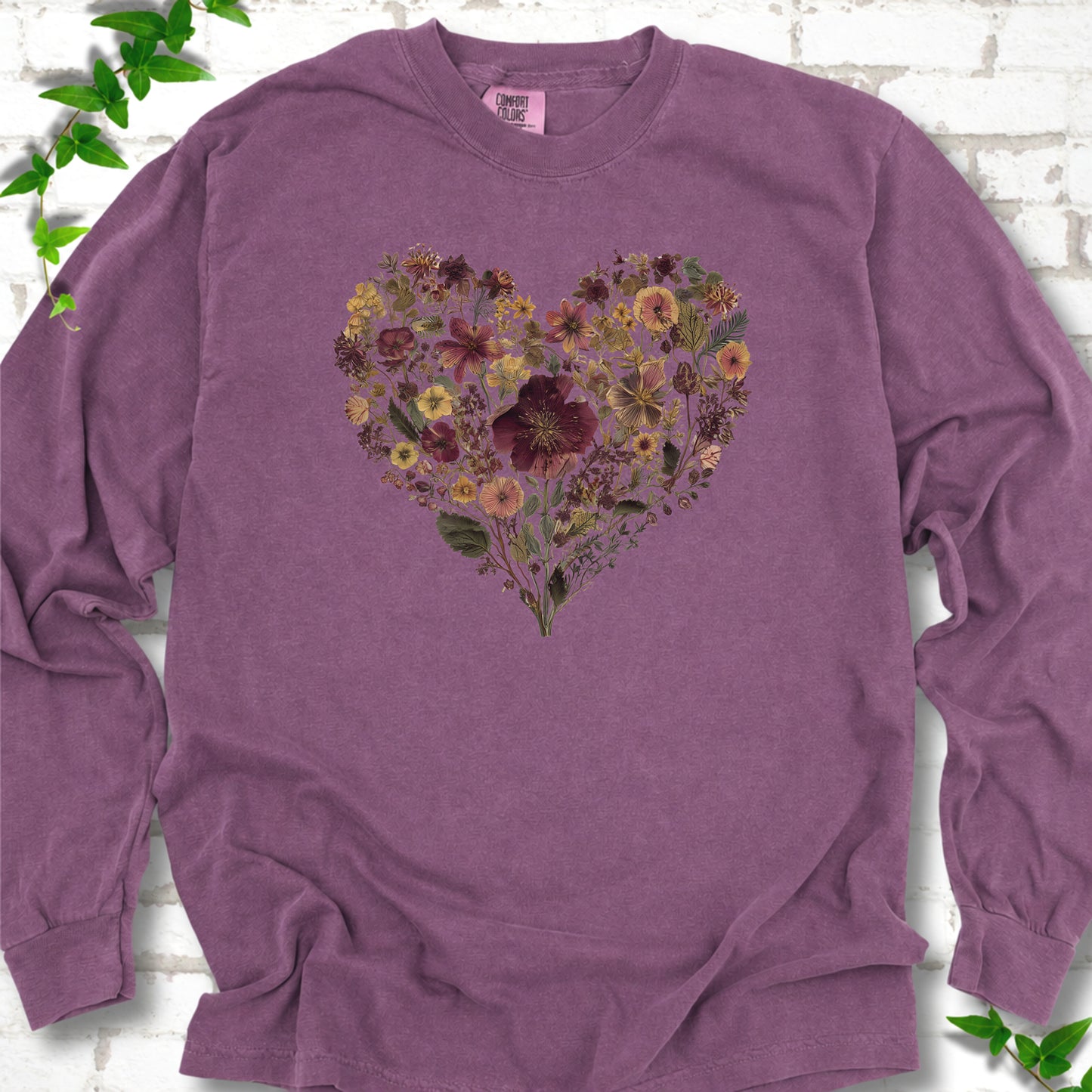 Berry Comfort Colors® long sleeve T-shirt flat lay featuring a heart formed from delicate wildflowers.