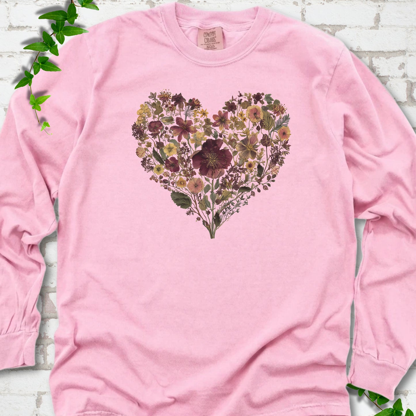 Blossom Comfort Colors® long sleeve T-shirt flat lay featuring a heart formed from delicate wildflowers.