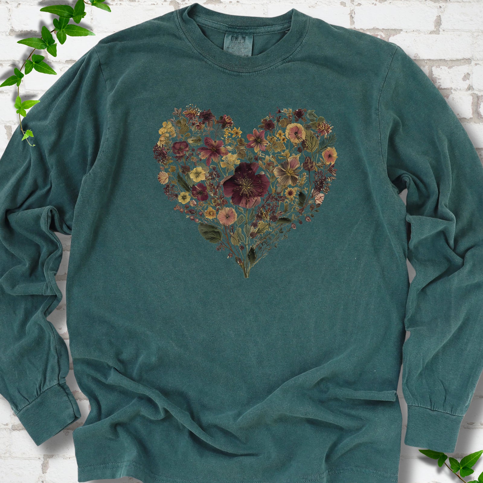 Blue Spruce Comfort Colors® long sleeve T-shirt flat lay featuring a heart formed from delicate wildflowers.