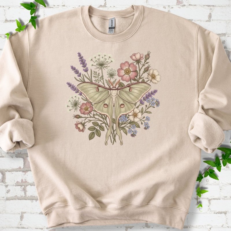 Sand Gildan® 18000 crewneck sweatshirt flat lay featuring a pale luna moth surrounded by pink, lavender, blue and white wildflowers.
