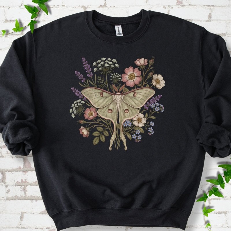 Black Gildan® 18000 crewneck sweatshirt flat lay featuring a pale luna moth surrounded by pink, lavender, blue and white wildflowers.