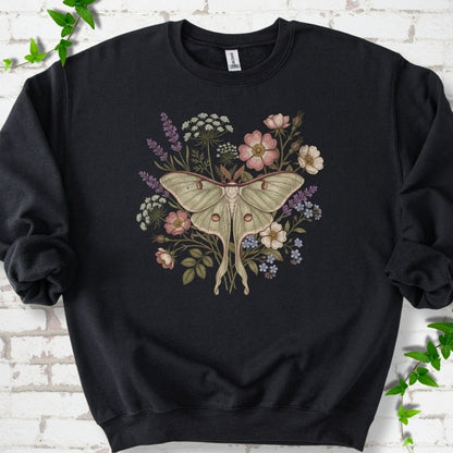 Black Gildan® 18000 crewneck sweatshirt flat lay featuring a pale luna moth surrounded by pink, lavender, blue and white wildflowers.