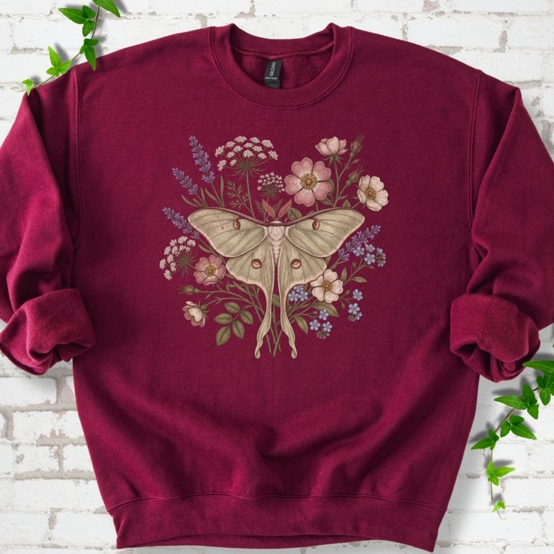 Maroon Gildan® 18000 crewneck sweatshirt flat lay featuring a pale luna moth surrounded by pink, lavender, blue and white wildflowers.