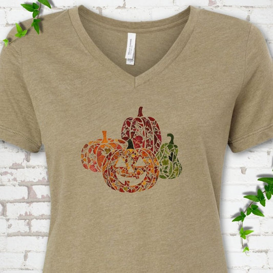 Heather Olive Bella Canvas® ladies' V-neck T-shirt flat lay featuring four pumpkins filled with colorful autumn leaves, ferns and wildflowers, including one smiling jack-o'-lantern.
