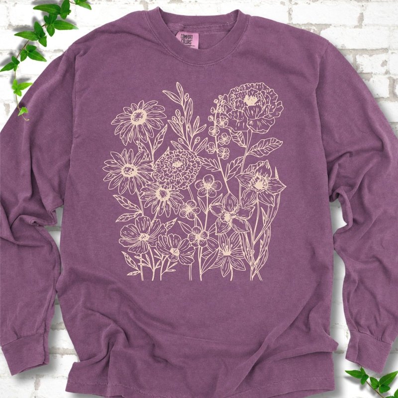 Berry Comfort Colors® long sleeve T-shirt flat lay featuring delicate cream wildflower line art.