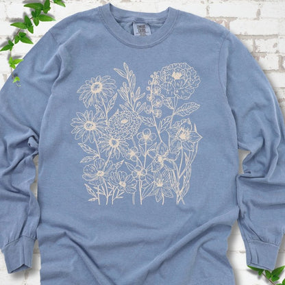Blue Jean Comfort Colors® long sleeve T-shirt flat lay featuring delicate cream wildflower line art.