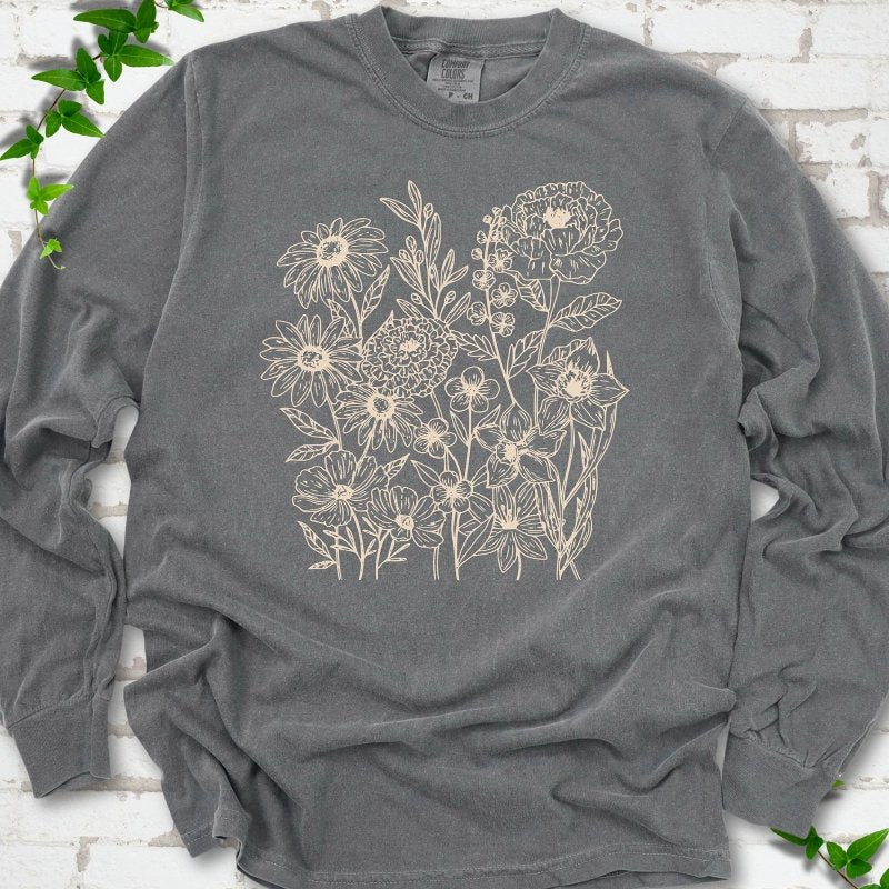 Pepper Comfort Colors® long sleeve T-shirt flat lay featuring delicate cream wildflower line art.