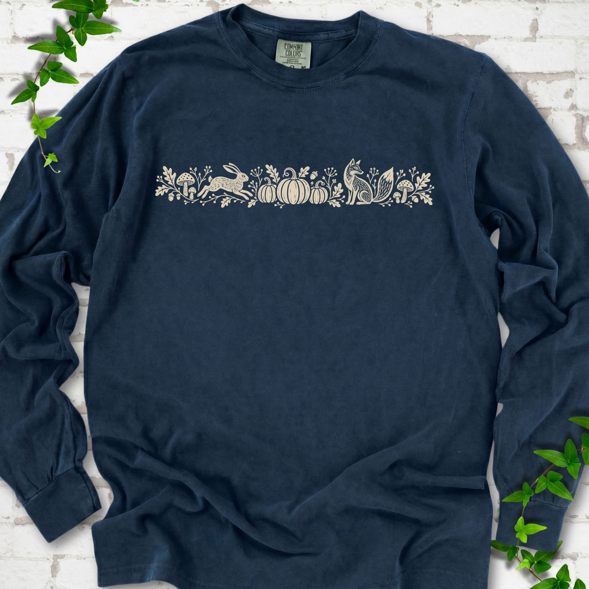 Midnight Comfort Colors® long sleeve shirt with a folk-style Woodland Harvest design of mushrooms, pumpkins and woodland animals.