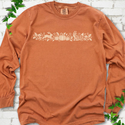 Pepper Comfort Colors® long sleeve shirt with a folk-style Woodland Harvest design of mushrooms, pumpkins and woodland animals.