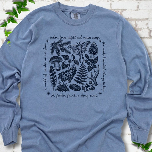 Blue Jean long-sleeve tee with woodland finds engraving in navy ink, framed by "a world of wonder at our feet".