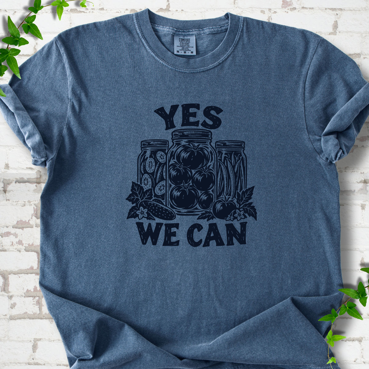 Denim Comfort Colors® T-shirt flat lay featuring preserved tomatoes in jars and the words “Yes We Can.”