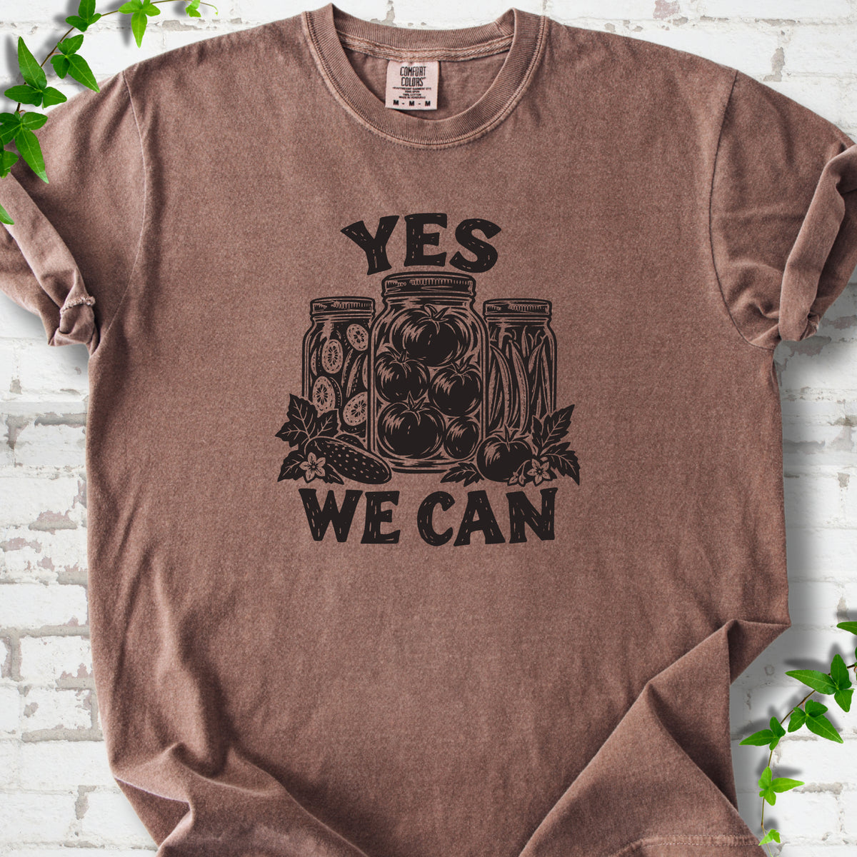 Espresso Comfort Colors® T-shirt flat lay featuring preserved tomatoes in jars and the words “Yes We Can.”