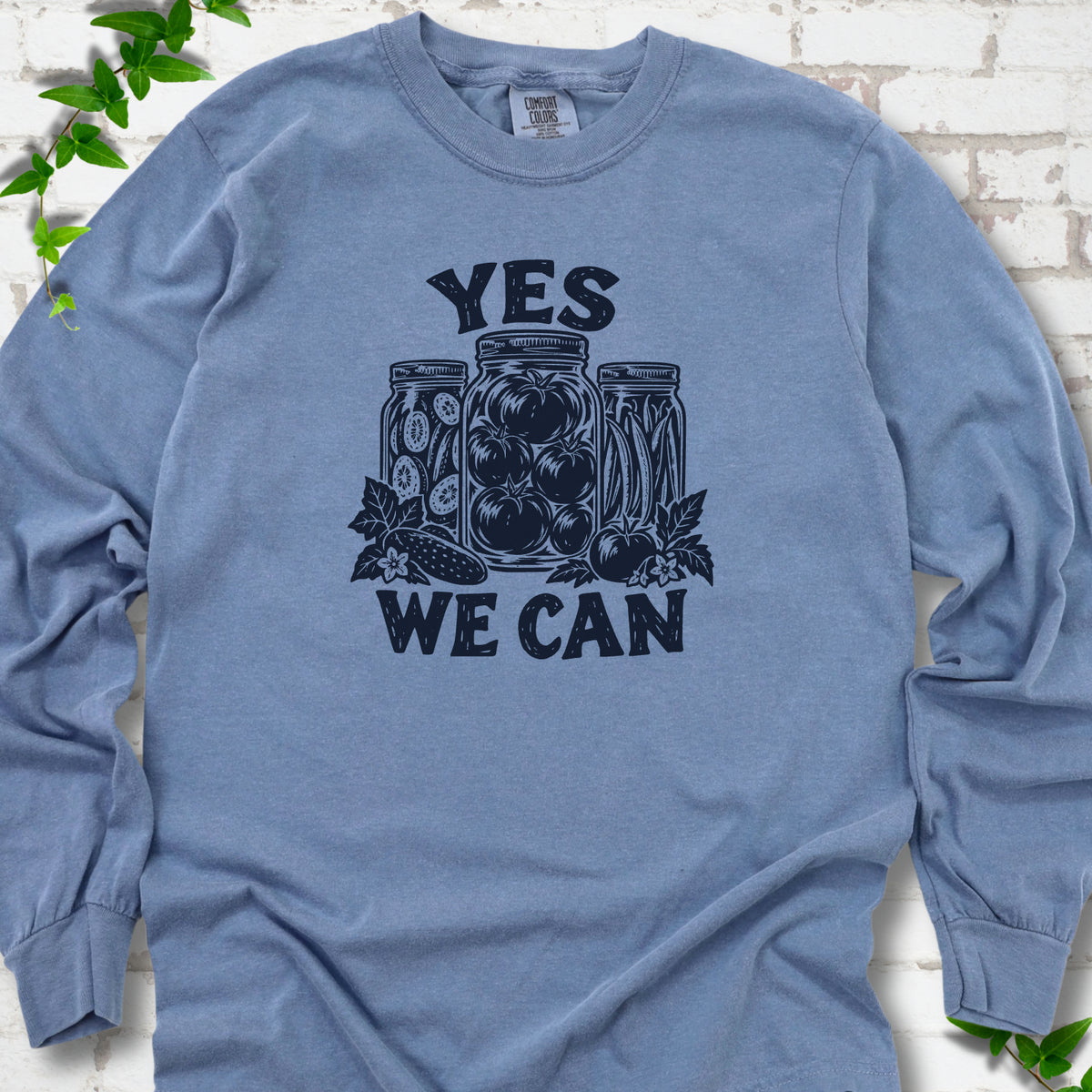 Blue Jean Comfort Colors® long sleeve T-shirt flat lay featuring preserved tomatoes in jars and the words “Yes We Can.”