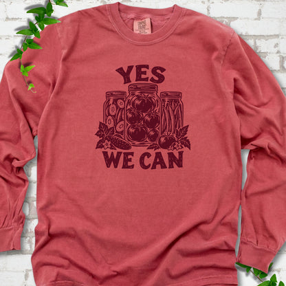 Crimson Comfort Colors® long sleeve T-shirt flat lay featuring preserved tomatoes in jars and the words “Yes We Can.”
