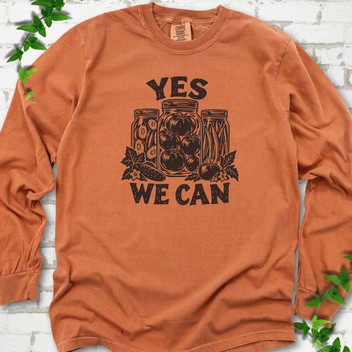 Yam Comfort Colors® long sleeve T-shirt flat lay featuring preserved tomatoes in jars and the words “Yes We Can.”