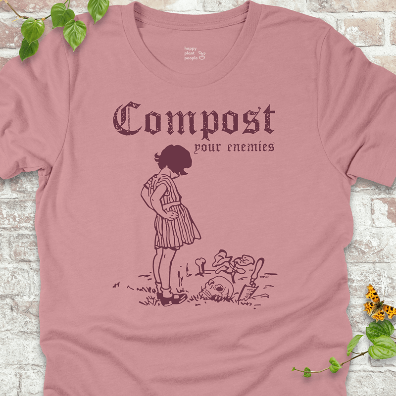 Funny goth gardening tee in dusty pink with skull, plants, and shovel