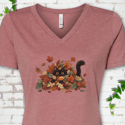 Heather Mauve Bella Canvas® V-neck T-shirt flat lay featuring a black cat peeking from a pile of orange and green autumn leaves.