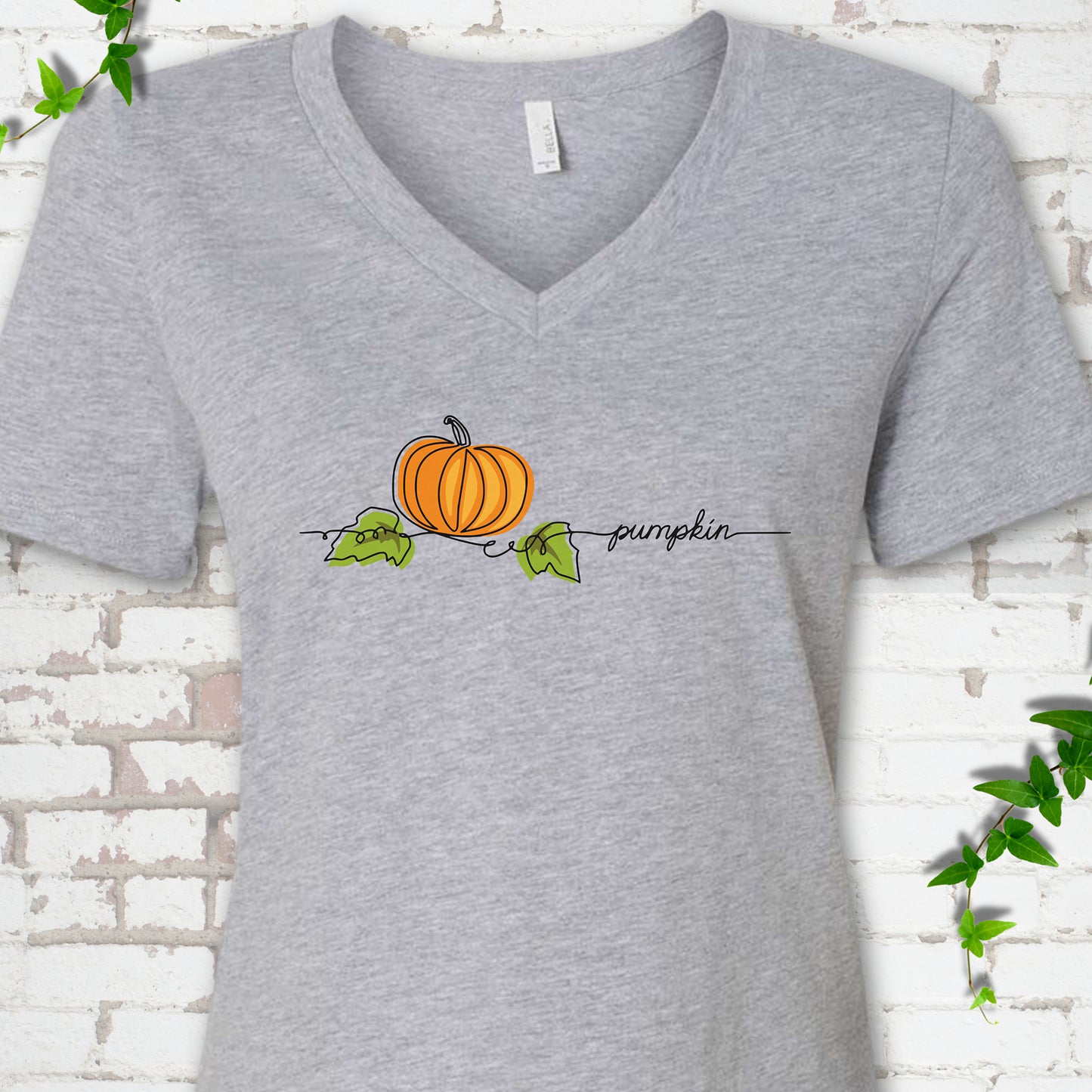 Athletic Heather Bella Canvas® V-neck T-shirt flat lay featuring a minimalist orange pumpkin, green leaves and delicate black script.