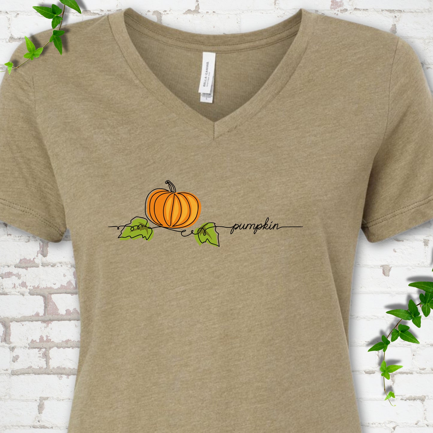 Heather Olive Bella Canvas® V-neck T-shirt flat lay featuring a minimalist orange pumpkin, green leaves and delicate black script.