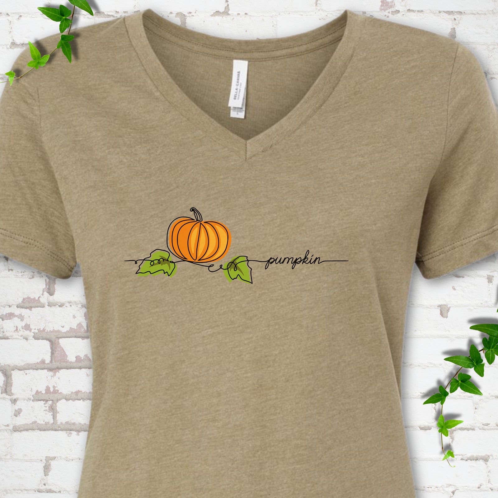 Heather Olive Bella Canvas® V-neck T-shirt flat lay featuring a minimalist orange pumpkin, green leaves and delicate black script.