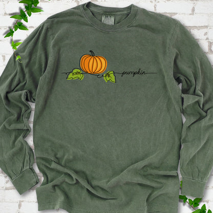 Hemp Comfort Colors® long sleeve T-shirt flat lay featuring a minimalist orange pumpkin, green leaves and delicate black script.