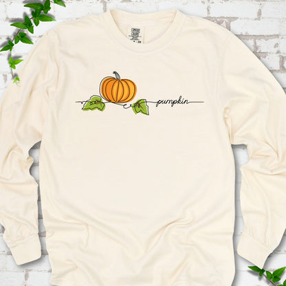 Ivory Comfort Colors® long sleeve T-shirt flat lay featuring a minimalist orange pumpkin, green leaves and delicate black script.