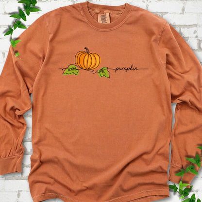 Yam Comfort Colors® long sleeve T-shirt flat lay featuring a minimalist orange pumpkin, green leaves and delicate black script.