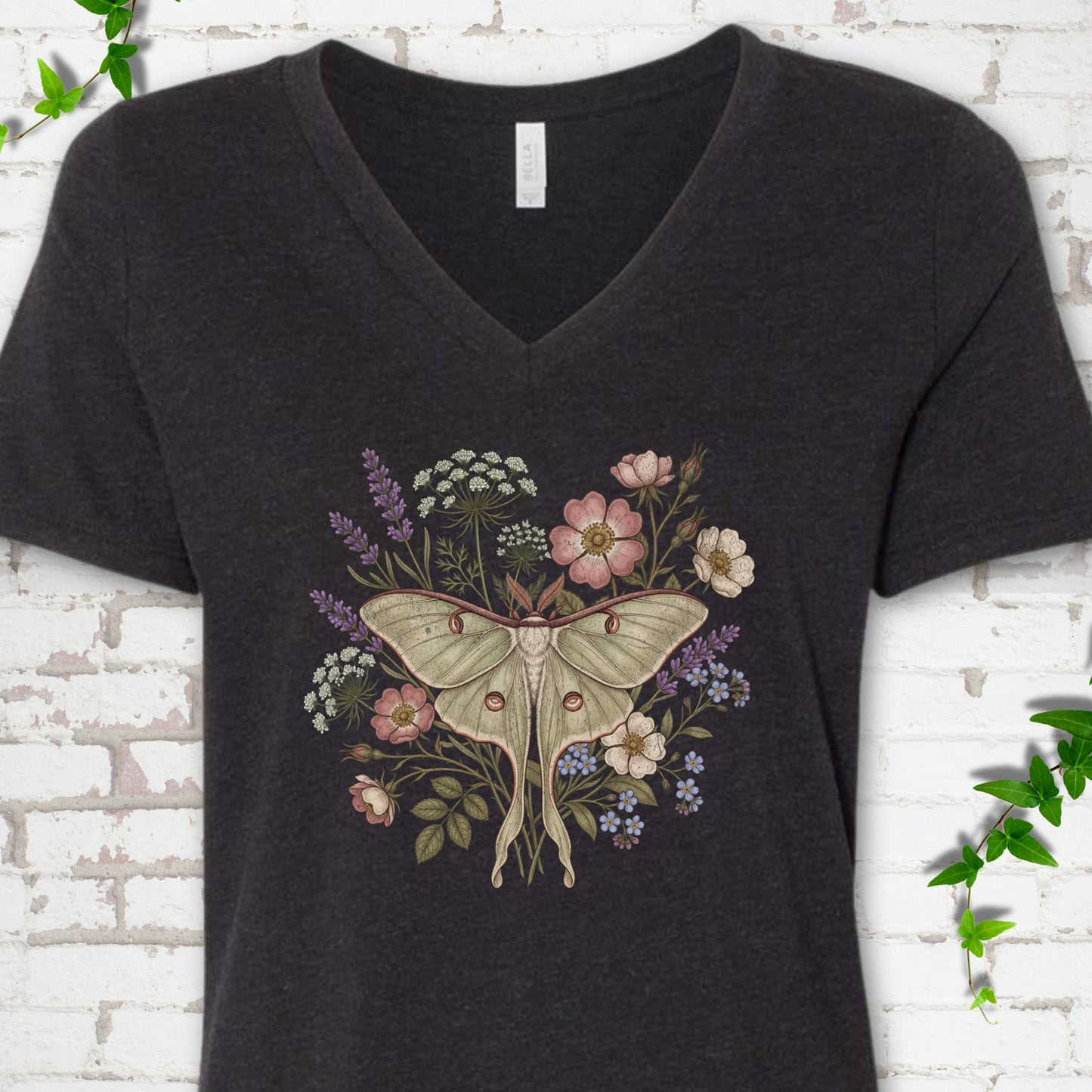Black Heather Bella Canvas® V-neck T-shirt flat lay featuring a pale luna moth surrounded by pink, lavender, blue and white wildflowers.