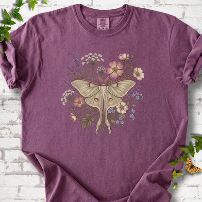 Berry Comfort Colors® T-shirt flat lay featuring a pale luna moth surrounded by pink, lavender, blue and white wildflowers.