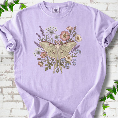 Orchid Comfort Colors® T-shirt flat lay featuring a pale luna moth surrounded by pink, lavender, blue and white wildflowers.