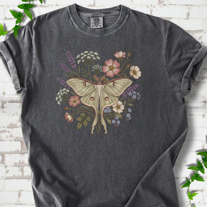Pepper Comfort Colors® T-shirt flat lay featuring a pale luna moth surrounded by pink, lavender, blue and white wildflowers.